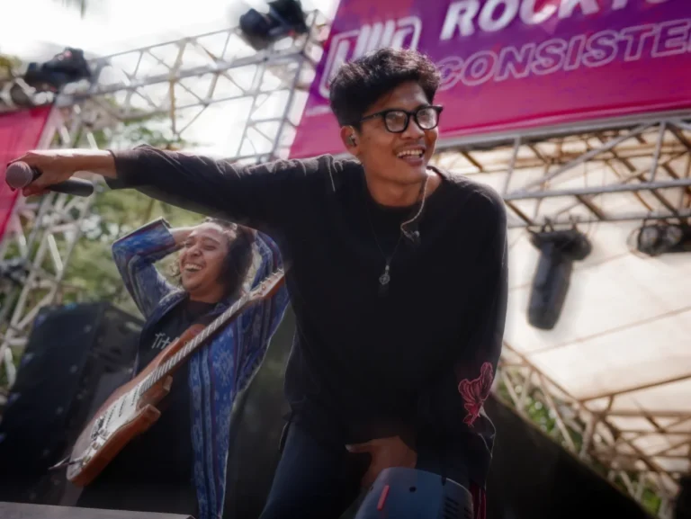 Vokalis Titik Temu, Danang, mengarahkan mikrofon ke penonton untuk sing along. Foto: Selaswara/Bayu